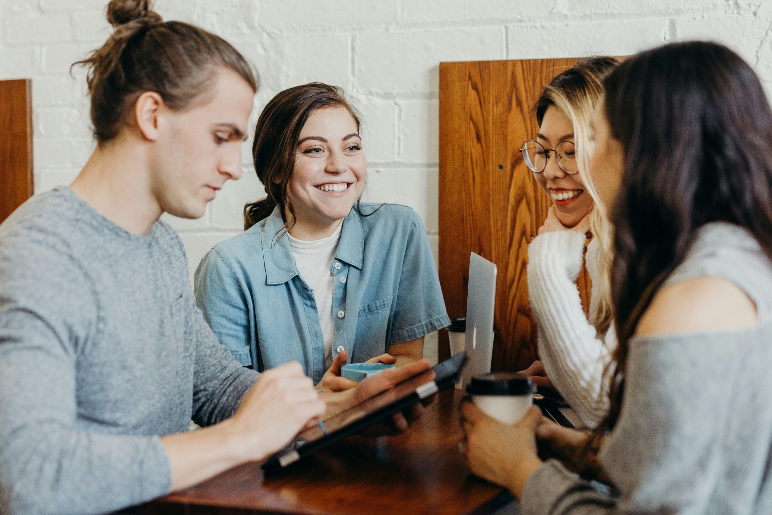 Grupo de estudiantes en un café interactuando con una tablet